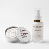 Frabella Natural Skincare moisturising cream shown with an open silver tin of white cream and a frosted white pump bottle with a gold band and clear cap on a light gray background.