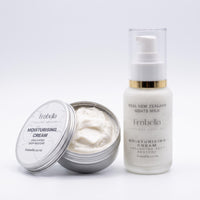 Frabella Unscented Deep Restore Moisturising Cream shown with an open silver tin containing white cream next to a white pump bottle with a gold collar and clear cap on a light gray background.